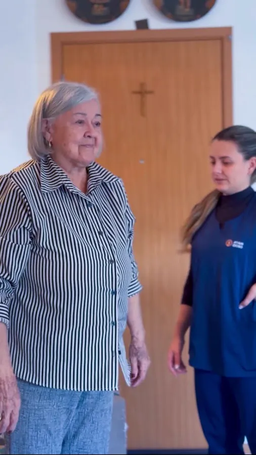 Pessoa idosa realizando treino de marcha com fisioterapeuta no domicilio
